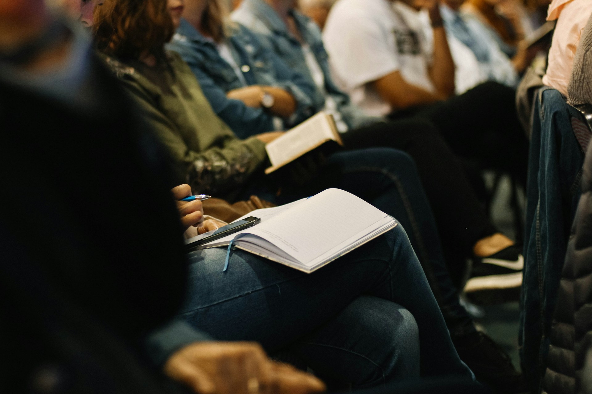 Adult with an open Bible taking notes during church